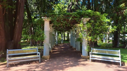Po&ccedil;os de Caldas, Minas Gerais, Brazil - February 26, 2023. Portal with Greek-style beams in the shape of a U and two square benches. Next to the flora clock and the fountain.