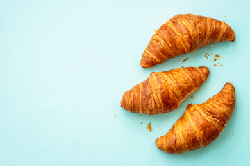 Croissant at blue background. French bakery. Flat lay image with copy space.
