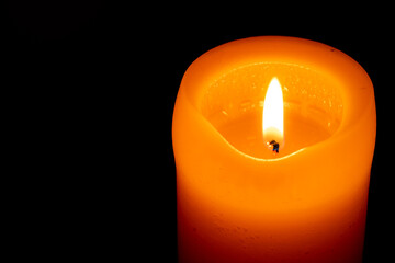 burning candle on black