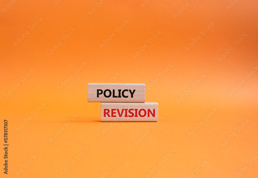 Wall mural Policy revision symbol. Concept word Policy revision on wooden blocks. Beautiful orange background. Business and Policy revision concept. Copy space