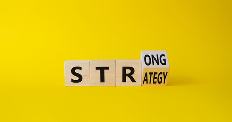 Strong Strategy symbol. Turned wooden cubes with words Strong Strategy. Beautiful yellow background. Business and Strong Strategy concept. Copy space