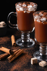 Two cups of hot chocolate, cocoa or warm drink with marshmallows on dark background