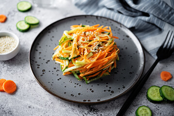 Fresh cucumber carrots salad with sesame seeds in a bowl