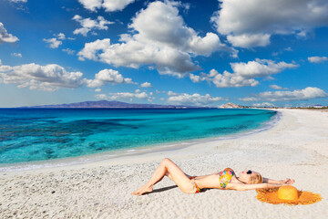 Fototapeta na wymiar A young woman lying at Sahara beach of Naxos island, Greece