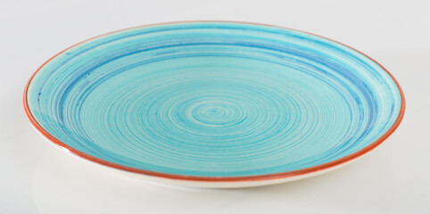 Empty blue dish with brown border placed on white surface.