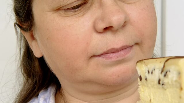 seductively appetizing piece of biscuit cake with chocolate, cream, marzipan on white plate in female hand, wants to eat dessert, calorie sweets concept, unhealthy food, homemade baking