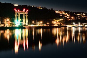 Fototapeta na wymiar Newfoundland night long exposure scene of the town of Placentia with street lights and the Sir Ambrose Shea Bridge reflecting on the ocean in Canada.