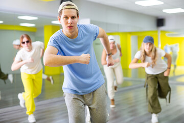Portrait of teenager boy performing hip hop at group dance class