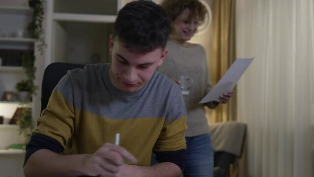 mature woman and son caucasian man teenager receive letter read good news student get scholarship or invitational letter from university share good news and excitement with his mother real people