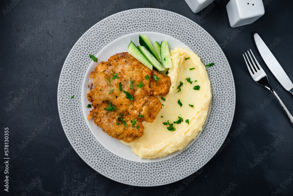 Sticker Breaded fried pork chop with mashed potatoes and cucumber.