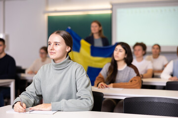 Young female student attentively listening to a lecture in a classroom