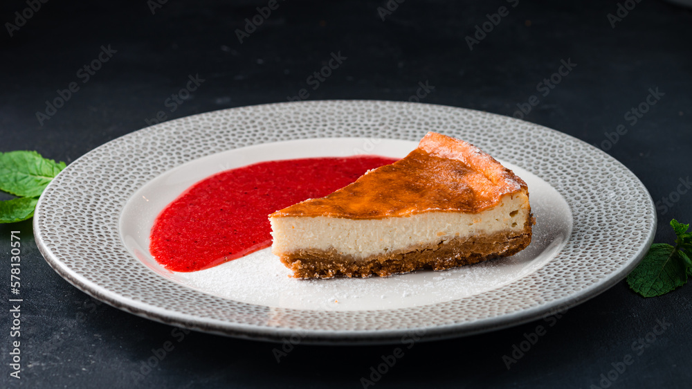 Poster piece of fresh cheesecake with berry sauce.