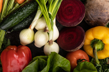Świeże surowe warzywa na ciemnym rustykalnym tle. Składniki zdrowej diety wegańskiej.