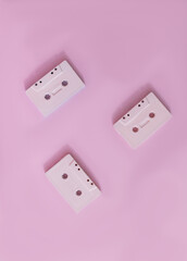 Three retro pink audio tapes on pink background. Minimal vertical design for wallpaper. Flat lay. Copy space.