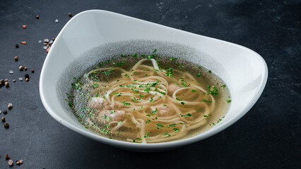 Hot soup with noodles and pork meatballs in a bowl.