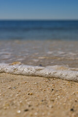 Bubbles on a wave washing up on beach