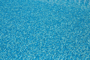 Fototapeta na wymiar Swimming pool bottom caustics ripple and flow with waves background. Summer background. Texture of water surface. Overhead view