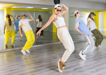 Young girl in sunglasses dancing modern dances in dance studio