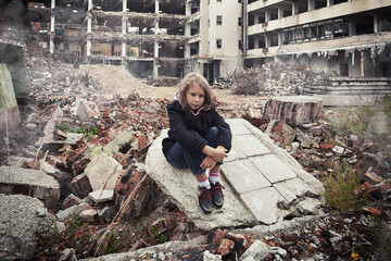 little girl sitting among ruins of house. Refugees concept. War crisis in Ukraine. Humanitarian...