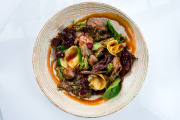 Salad with beef slices, zucchini, cranberries, lettuce, spinach and sauce.