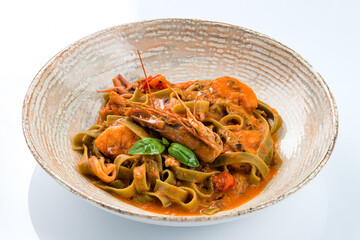 Green pasta Linguini with spinach, tomatoes, shrimps, crayfish and sauce.