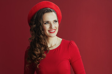 happy elegant female in red dress and beret on red background