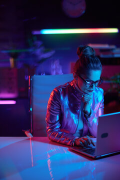 pensive elegant business woman in glasses using laptop