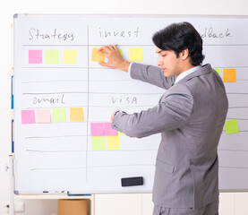 Young handsome employee working in the office