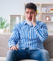 Fototapeta premium Young man suffering a neck spine head trauma wearing a cervical