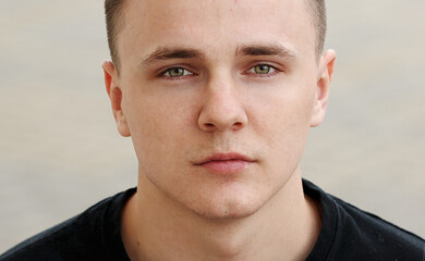 concentrated handsome young man with brown eyes and healthy skin looking to camera. expressive interesting face expression