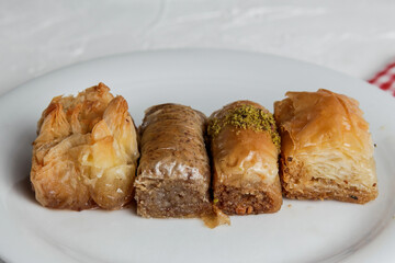 Traditional turkish dessert antep baklava with pistachio on rustic table, holiday desserts concept, Delicious rhombus shaped Turkish village baklava with walnuts in a tray, Pistachio baklava closeup.