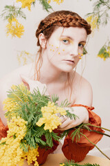 Woman with mimosa flowers and yellow make-up