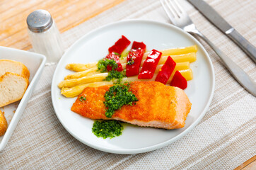 Appetizing Roasted salmon steak with asparagus, pepper and herbs in a cafe