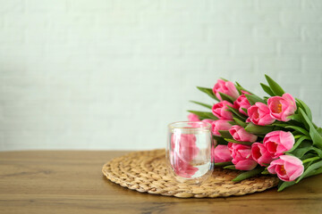 Fototapeta na wymiar Glass of water and bunch of flowers, good morning concept