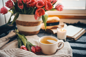 Obraz na płótnie Canvas Cup of tea and basket with tulips, aesthetic still life