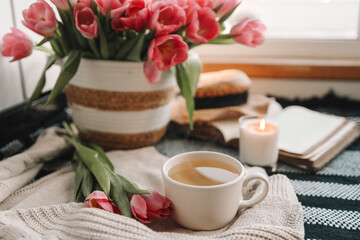 Fototapeta na wymiar Cup of tea and basket with tulips, aesthetic still life