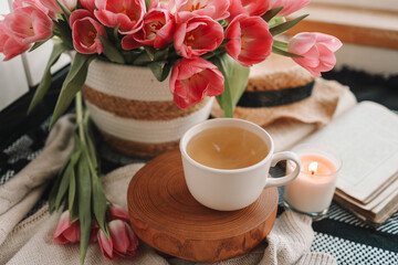 Fototapeta na wymiar Cup of tea and basket with tulips, aesthetic still life
