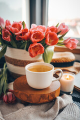 Cup of tea and basket with tulips, aesthetic still life