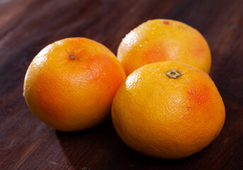 Closeup of whole ripe yellow pomelo on wooden table. Vitamin fruits