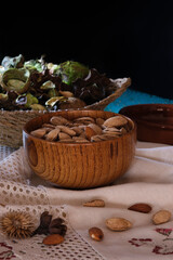 Still life of dried fruits, vertical shot, toasted almonds on a mat and dried flowers