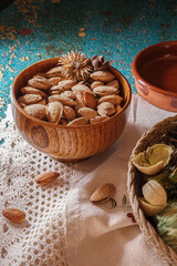 Still life of dried fruits, vertical shot, toasted almonds on a mat and dried flowers