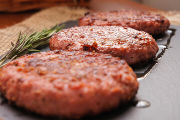 Close-up beef burgers accompanied by rosemary made on the grill