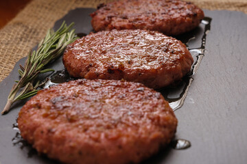 Close-up beef burgers accompanied by rosemary made on the grill