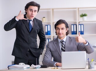 Two young employees working in the office