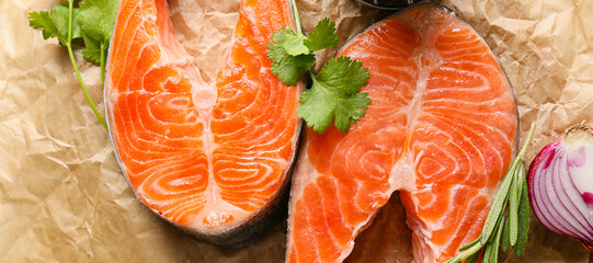 Raw salmon steaks and spices on table, closeup