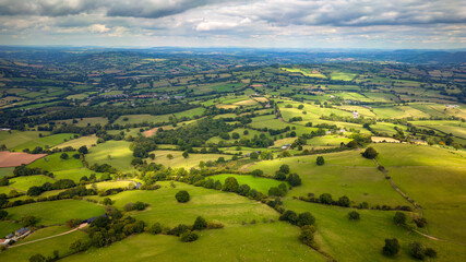 Aerial view of rural farmland and fields in a hilly area (South Wales)