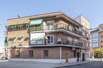 facade of an urban residential building of three heights with balconies with black metal railings