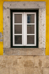Wooden exterior window of an old house with a stone facade