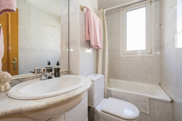 Small bathroom with a square white porcelain sink on a wooden cabinet, a frameless mirror on the wall, and a glass-enclosed shower stall