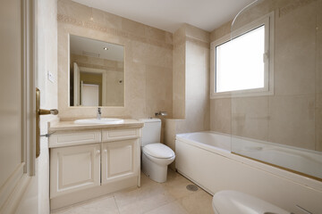 Fototapeta na wymiar Bathroom with white hydromassage bathtub with glass partition, square mirror embedded in the wall, wooden furniture, square white aluminum window and marble tiled walls